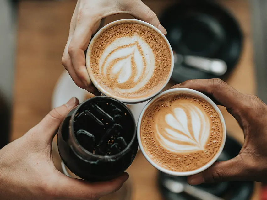 Manos chocando tazas de cafe y refrescos
